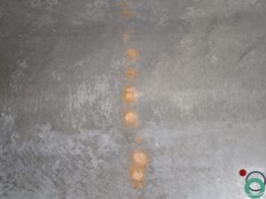 Dieptereiniging van de vloer in een ondergrondse parkeergarage met zichtbare vervuiling en reinigingssporen